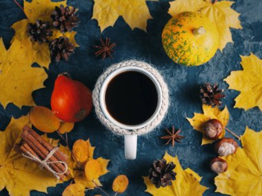 Sarı akçaağaç yapraklı taze demlenmiş bir kahve fincanının en üst görüntüsü.