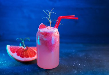 Greyfurt alkollü mojito kokteyli, cin, biberiye filizi, buzlu dondurma, ferahlatıcı yaz limonatası, mavi arka plan.