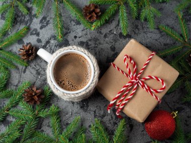 Sıcak sabah kahvesi ve Noel hediyesi masanın üzerinde ağaç dallarıyla.