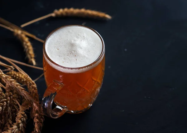 Een Mok Ongefilterd Licht Bier Een Zwarte Tafel Tarweoren — Stockfoto