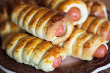 Ahşap bir masanın üzerindeki hamurda sosisler