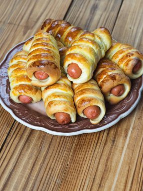 Ahşap bir masanın üzerindeki hamurda sosisler