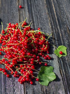 Siyah ahşap masada kırmızı frenk üzümü.