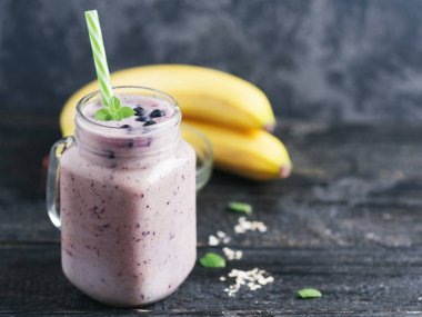 Böğürtlenli ve muzlu bir kavanoz koyu smoothie.