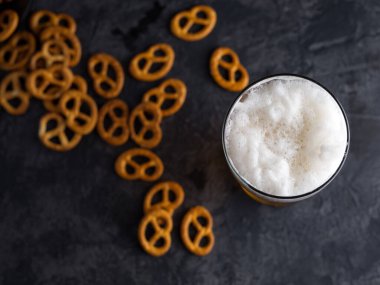 Bir bardak buğday birası ve geleneksel atıştırmalık tuzlu kraker.