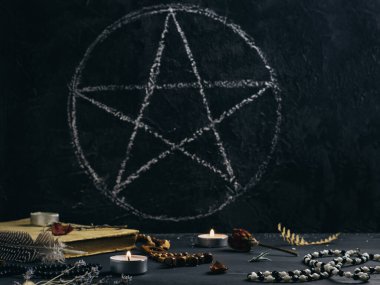 Antik büyü, pentagram, mumlar ve sembollerle ilgili kitaplarla dolu mistik bir hayat.
