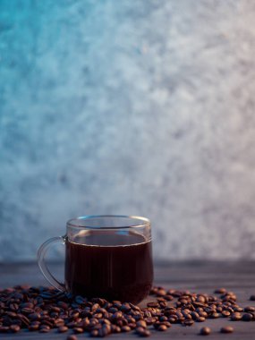 Cam espresso kahve fincanı kavrulmuş kahve çekirdeklerinin üzerinde duruyor.