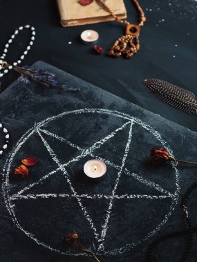 Kara büyü ayini, okültizm kavramı, tahtaya çizilmiş bir pentagram, eski bir büyü kitabı.