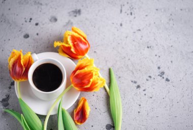 Bir fincan aromatik espresso kahve, bir buket kırmızı ve sarı lale, uluslararası kadınlar günü için kopyalanmış bir kartpostal.