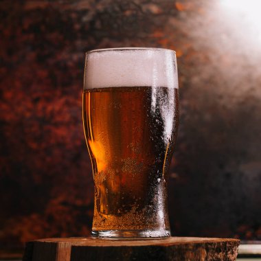 Paslı arka planda yarım bardak light bira.