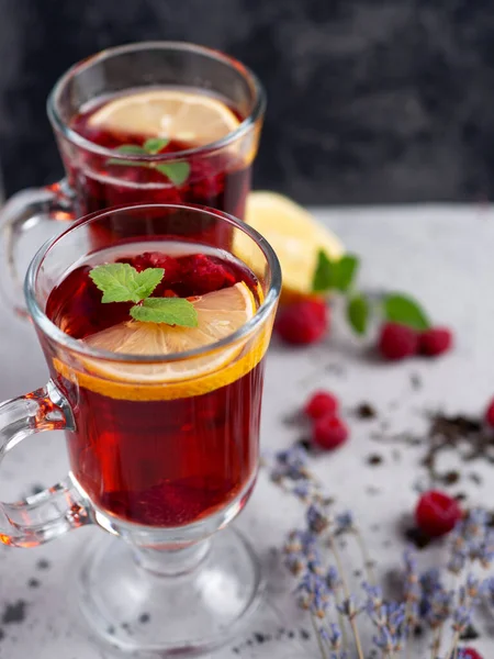 Red tea with raspberries in glass