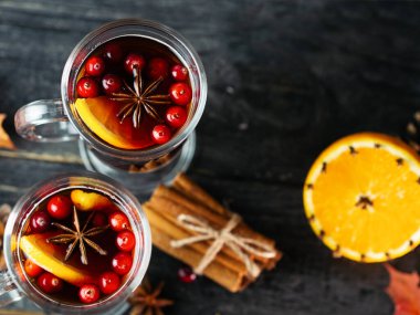 İki bardak alkollü şarap, ahşap bir masada tarçınlı, portakallı, anason