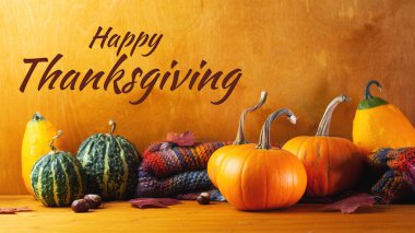 Mutlu Şükran Günleri. Sonbahar farklı balkabakları, akçaağaç yaprakları, ahşap bir kırsal masada örülmüş eşarp.