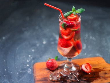 Kırmızı pipetle bardakta çilek ferahlatıcı buzlu tonik kokteyli.