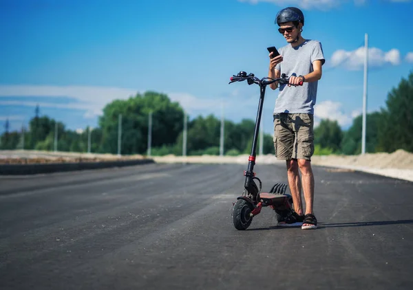 Egy Fiatalember Sisakot Visel Egy Modern Erős Elektromos Robogón Egy — Stock Fotó