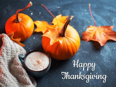 Şükran Günü kavramsal kompozisyonun kutlu olsun. Masada bir fincan kokulu sıcak kahve, sonbahar balkabakları, sıcak bir eşarp ve sarı akçaağaç yaprakları.