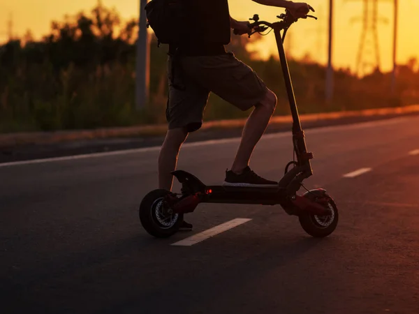 Kerl Auf Einem Elektroroller Unterwegs Bei Sonnenuntergang Nahaufnahme Selektiver Fokus — Stockfoto