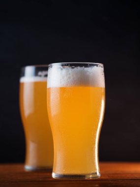 Siyah arka planda iki bardak buğday birası yakın plan.