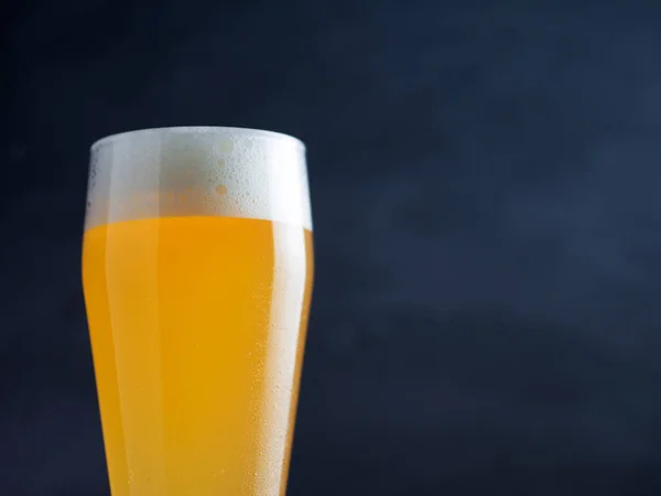 暗い背景に背の高いガラスの中の小麦ビールのガラス — ストック写真