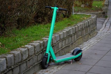Kaldırıma park etmiş yeşil bir scooter.