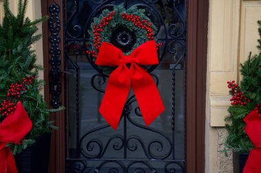 Tatil için dekoratif işlenmiş demir kapıya asılmış bir Noel çelengi..