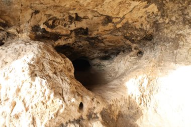 Doğal bir mağaranın gizemli derinliklerini keşfedin. Karmaşık kaya dokuları ve daha fazla keşfi çağrıştıran loş bir pasajla.