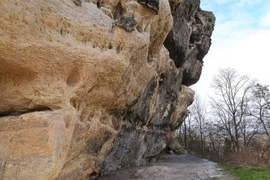 Büyük bir kum taşı oluşumunun dokulu yüzeyi erozyon ve yıpranma belirtileri gösteriyor.