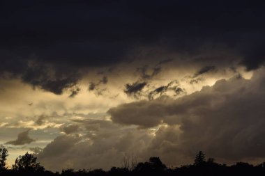 Bulutlu bir gün batımı parlak ve resim gibi bir gökyüzü yaratıyor. Sahne sıcaklığı, sükuneti ve doğal güzelliği yansıtıyor..