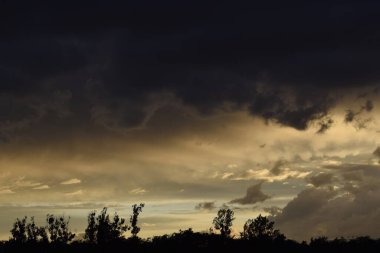 Bulutlu bir gün batımı parlak ve resim gibi bir gökyüzü yaratıyor. Sahne sıcaklığı, sükuneti ve doğal güzelliği yansıtıyor..
