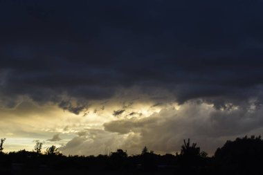Bulutlu bir gün batımı parlak ve resim gibi bir gökyüzü yaratıyor. Sahne sıcaklığı, sükuneti ve doğal güzelliği yansıtıyor..