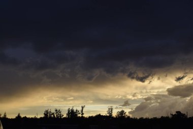 Bulutlu bir gün batımı parlak ve resim gibi bir gökyüzü yaratıyor. Sahne sıcaklığı, sükuneti ve doğal güzelliği yansıtıyor..