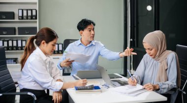 Öfkeli Asyalı iş adamları modern ofiste bir hata yaptıktan sonra şiddetle tartışıyorlar.