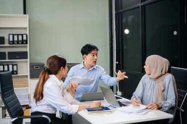 Öfkeli Asyalı iş adamları modern ofiste bir hata yaptıktan sonra şiddetle tartışıyorlar.