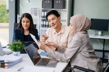 İş ekibi toplantı odasında tartışır. Masada dizüstü bilgisayar, tablet ve akıllı telefonla çalışmak. Muhasebeci, planlamacı, toplantı, konsept. Ofiste.