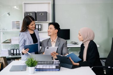 Bir grup genç Asyalı iş adamı modern iş hayatında iş planlarını tartışıyor modern ofis inşaatını tartışıyorlar.