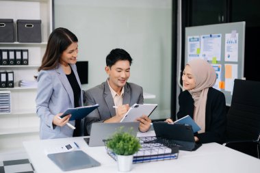 Bir grup genç Asyalı iş adamı modern iş hayatında iş planlarını tartışıyor modern ofis inşaatını tartışıyorlar.