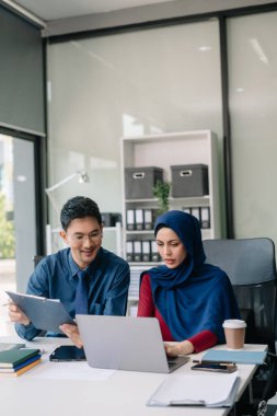 Ofiste yeni bir proje üzerinde çalışırken mutlu iş adamları. Ofiste bir dizüstü bilgisayar ve tablet kullanan bir grup iş adamı