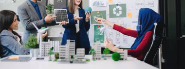 Bir grup alternatif enerji mühendisi, bir iş adamıyla bir projeyi tartışıyor güneş pili paneli ve Güneş Enerjisi Çevre Şehri Konsepti 'nde bir toplantı yapıyor. Ofiste.