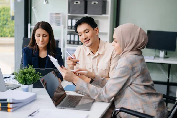 İş ekibi toplantı odasında tartışır. Masada dizüstü bilgisayar, tablet ve akıllı telefonla çalışmak. Muhasebeci, planlamacı, toplantı, konsept. Ofiste.