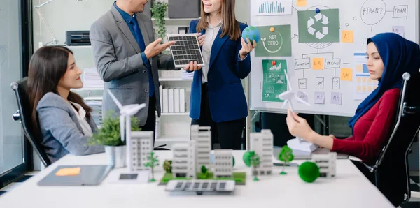 Bir grup alternatif enerji mühendisi, bir iş adamıyla bir projeyi tartışıyor güneş pili paneli ve Güneş Enerjisi Çevre Şehri Konsepti 'nde bir toplantı yapıyor. Ofiste.