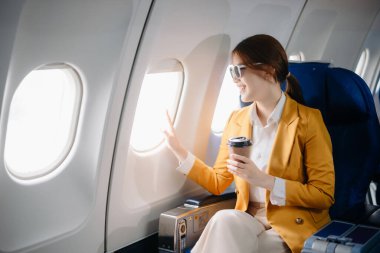 Birinci sınıfta Tablet 'te çalışan Asyalı Kadın, Uçuş Yolculuğu' nu çok yönlü, zarafetle çalışıyor.