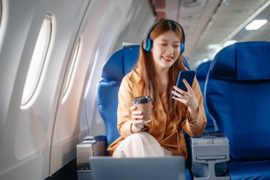 Birinci sınıfta Tablet 'te çalışan Asyalı Kadın, Uçuş Yolculuğu' nu çok yönlü, zarafetle çalışıyor.