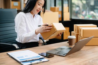 Küçük işletmeler kuran KOBİ sahipleri, çevrimiçi siparişleri kontrol eden iki kişi, iç pazarlama, ambalaj, konsept gibi şirketlerde kutu serbest iş yapan ürünler satıyor.