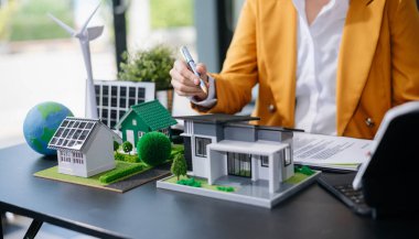 Emlak sektörünü dengelemek için emlakçı ev tasarımını ve satın alma anlaşmasını görmek için ev tarzını açıklıyor. Ofiste model ev ve komdo.