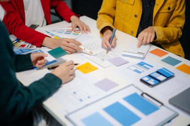 UI müteahhitlerinin projelerini dizüstü bilgisayar, akıllı telefon ve dijital tablet ile beyin fırtınası yaparken görüntülerini kapatın. Yaratıcı dijital geliştirme ajansı