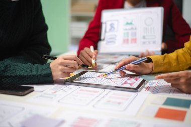 UI müteahhitlerinin projelerini dizüstü bilgisayar, akıllı telefon ve dijital tablet ile beyin fırtınası yaparken görüntülerini kapatın. Yaratıcı dijital geliştirme ajansı.