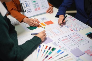 UI müteahhitlerinin projelerini dizüstü bilgisayar, akıllı telefon ve dijital tablet ile beyin fırtınası yaparken görüntülerini kapatın. Yaratıcı dijital geliştirme ajansı.