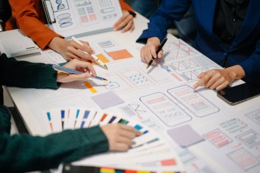 UI müteahhitlerinin projelerini dizüstü bilgisayar, akıllı telefon ve dijital tablet ile beyin fırtınası yaparken görüntülerini kapatın. Yaratıcı dijital geliştirme ajansı.