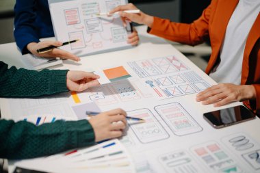 UI müteahhitlerinin projelerini dizüstü bilgisayar, akıllı telefon ve dijital tablet ile beyin fırtınası yaparken görüntülerini kapatın. Yaratıcı dijital geliştirme ajansı.