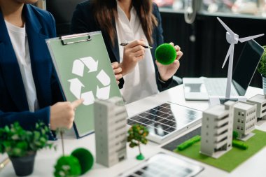 Business people having consultation about wind energy at company office. Business team discussing about windmill and alternative green energy. Executive meeting 